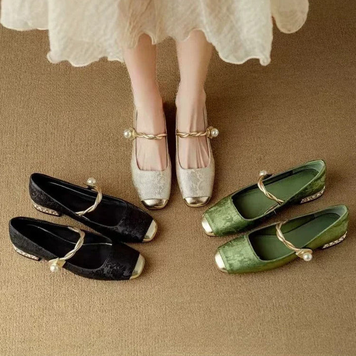 A woman wearing green low-heel Mary Janes with a twisted gold strap, gilded cap toe and a crystal-set heel