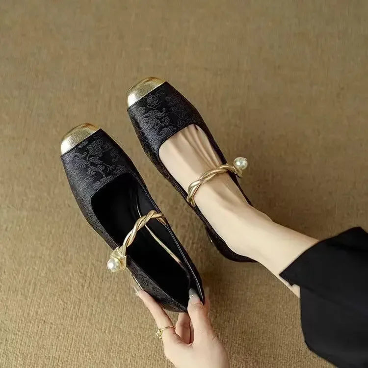 A woman wearing green low-heel Mary Janes with a twisted gold strap, gilded cap toe and a crystal-set heel