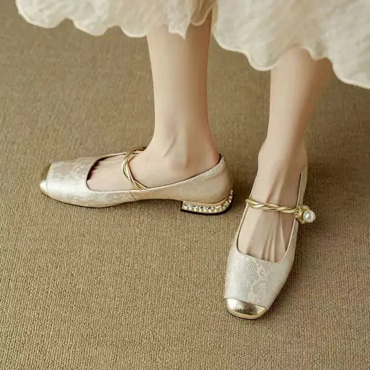A woman wearing green low-heel Mary Janes with a twisted gold strap, gilded cap toe and a crystal-set heel