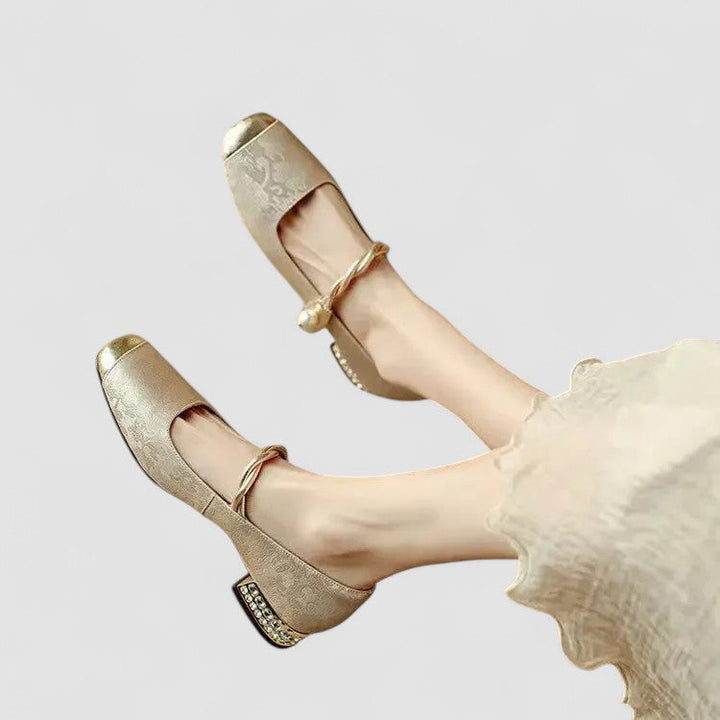A woman in sparkling Mary Jane shoes with a low block heel at an evening celebration.