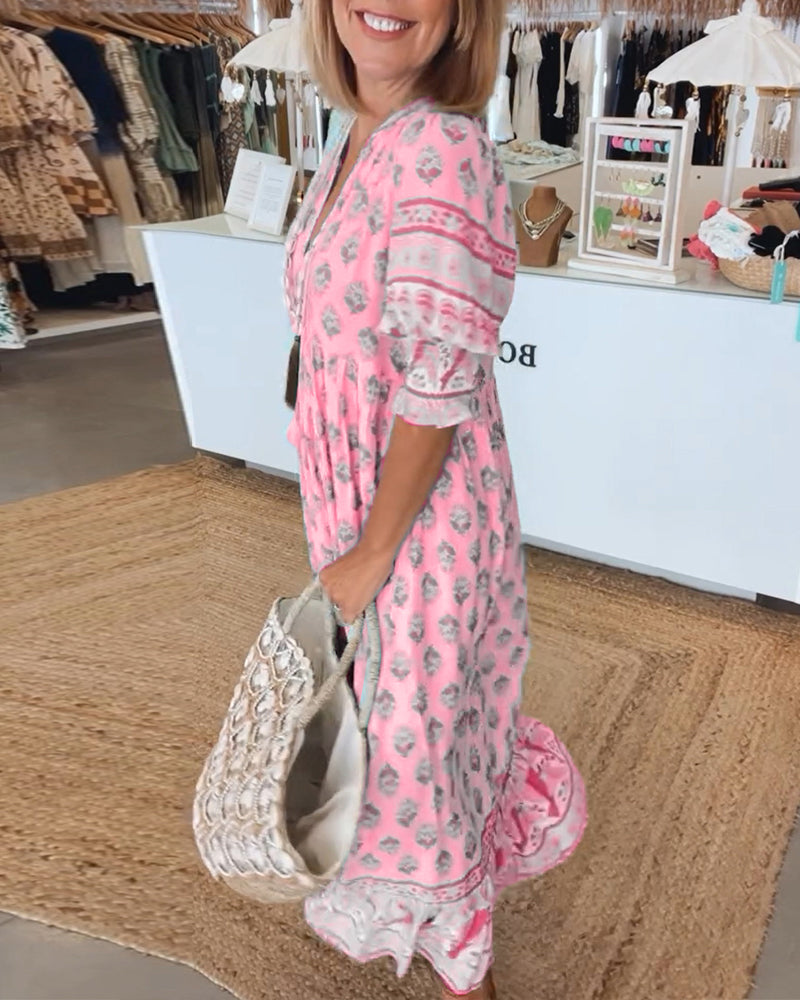 A woman wearing the Crystal boho beach dress with a flowing skirt, walking along the seaside.