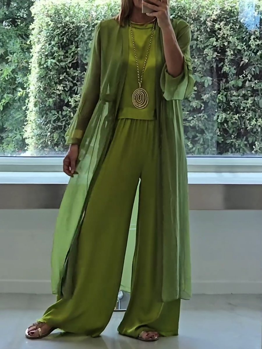 A woman wearing a flowing three-piece set with a sleeveless top, wide pants and a long cardigan.