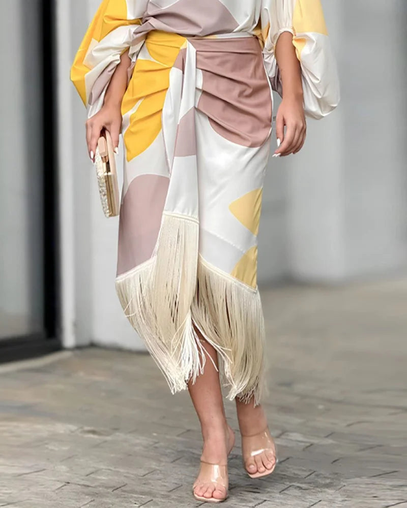 A woman wearing a bold-print one-shoulder two-piece set with a flowing hem