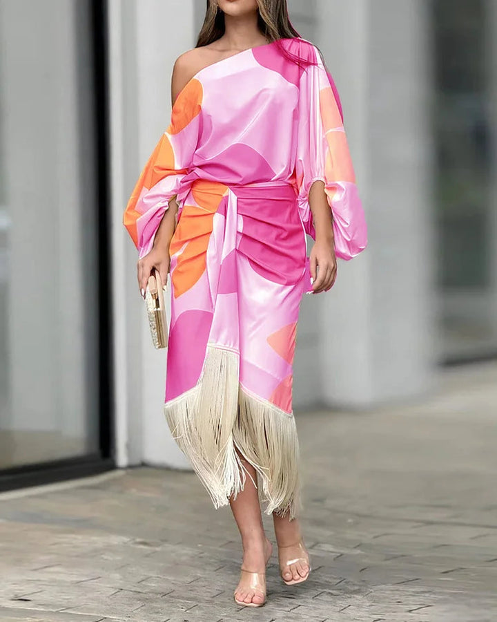 A woman wearing a bold-print one-shoulder two-piece set with a flowing hem
