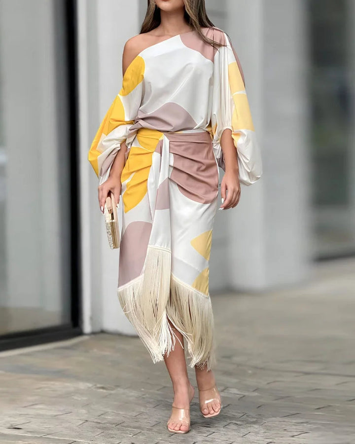 A woman wearing a bold-print one-shoulder two-piece set with a flowing hem