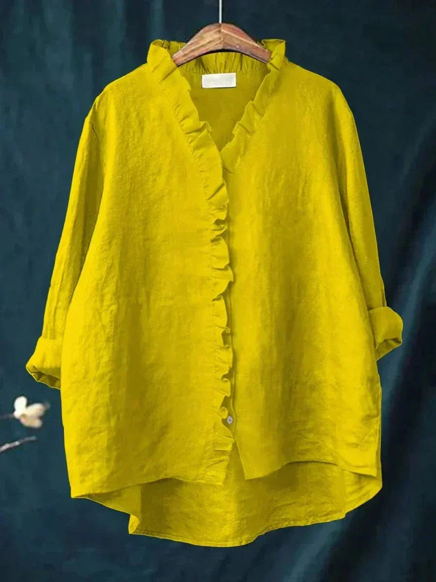 Woman wearing a plain ruffle-front summer blouse with a soft, flowing silhouette.