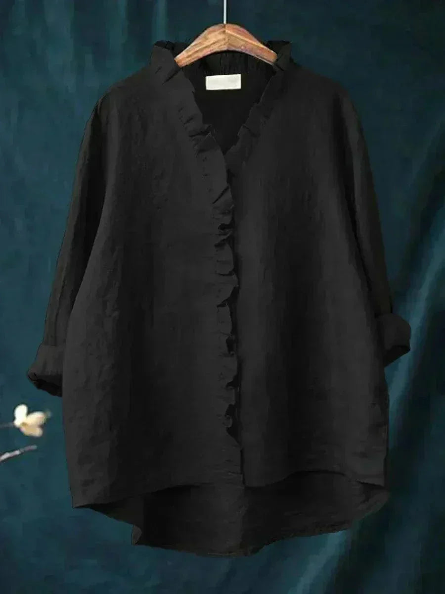 Woman wearing a plain ruffle-front summer blouse with a soft, flowing silhouette.