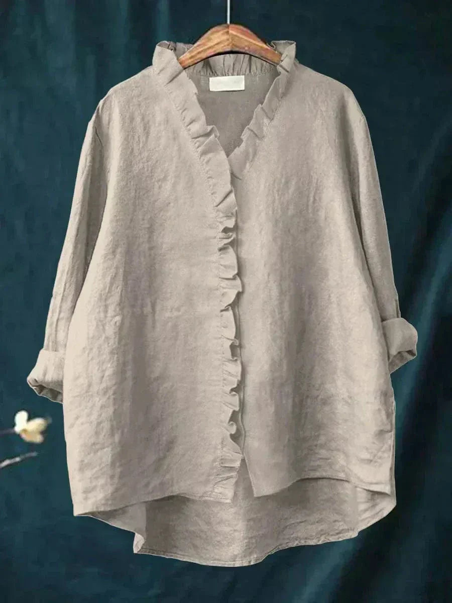 Woman wearing a plain ruffle-front summer blouse with a soft, flowing silhouette.