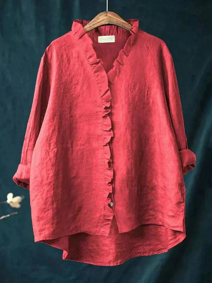Woman wearing a plain ruffle-front summer blouse with a soft, flowing silhouette.