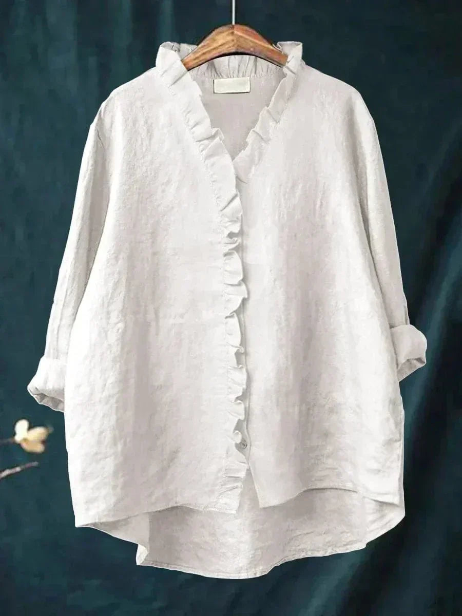 Woman wearing a plain ruffle-front summer blouse with a soft, flowing silhouette.