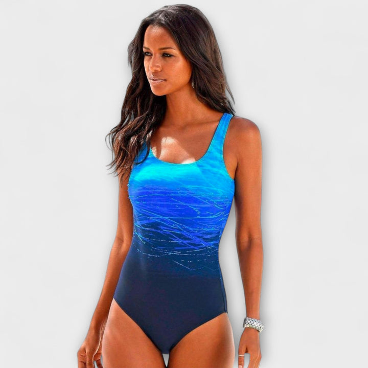 A woman at the pool in a sporty one-piece swimsuit, active and confident in the sunshine.