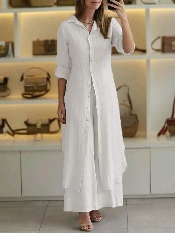 A woman wearing an elegant dress layered with flowing wide-leg pants.