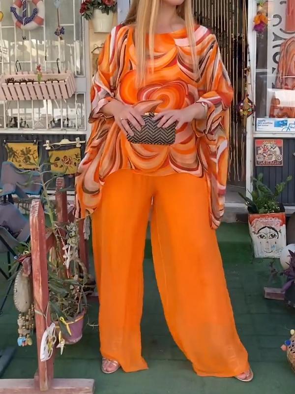 A woman wearing a swirl-print top with flowing wide-leg pants