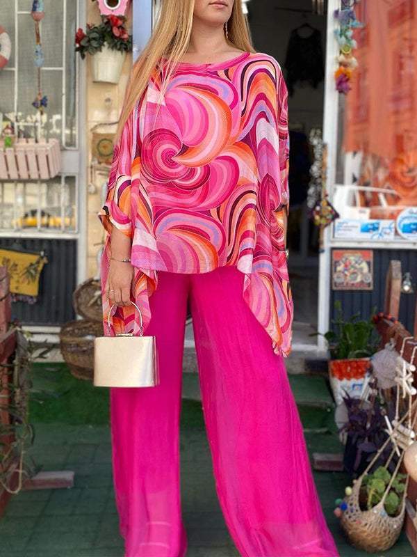 A woman wearing a swirl-print top with flowing wide-leg pants