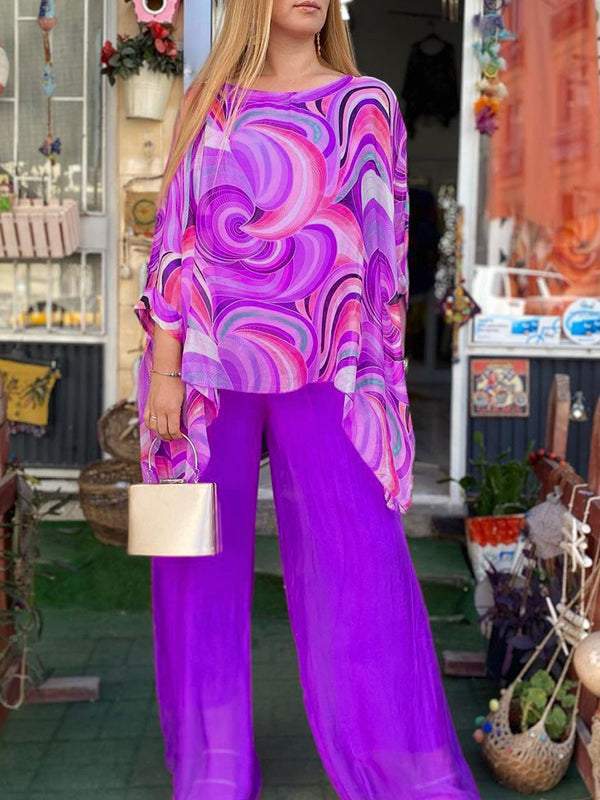 A woman wearing a swirl-print top with flowing wide-leg pants
