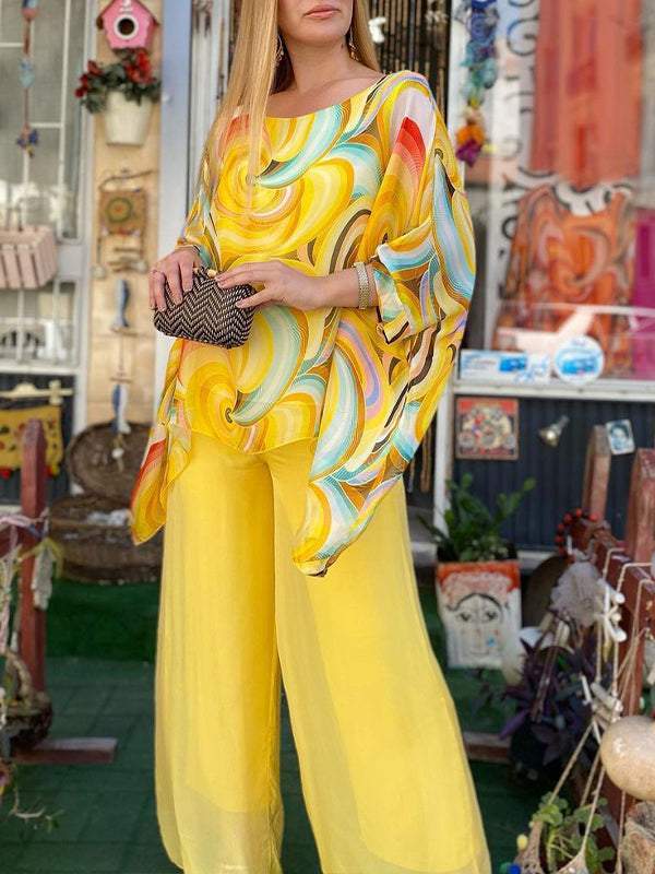 A woman wearing a swirl-print top with flowing wide-leg pants