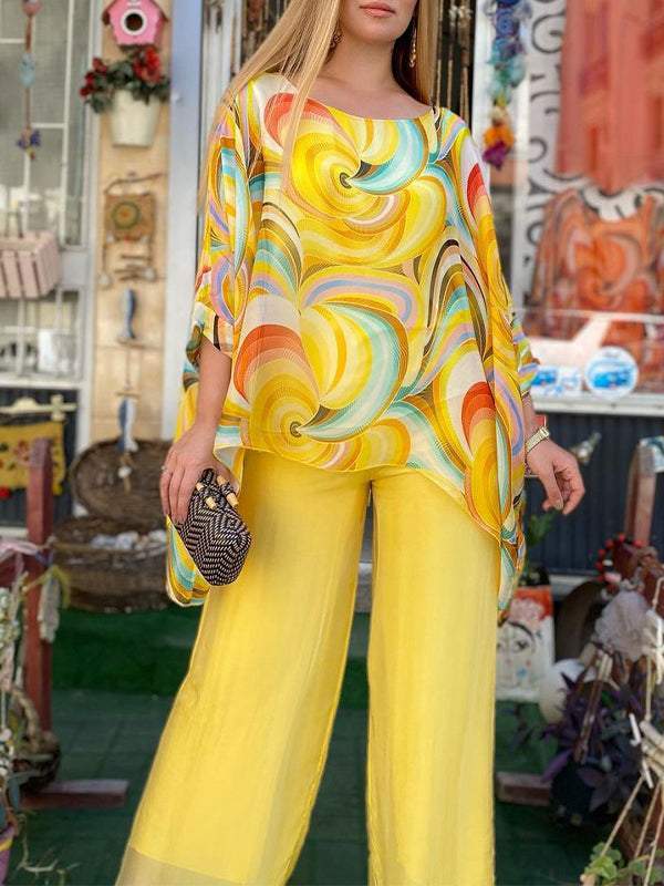 A woman wearing a swirl-print top with flowing wide-leg pants