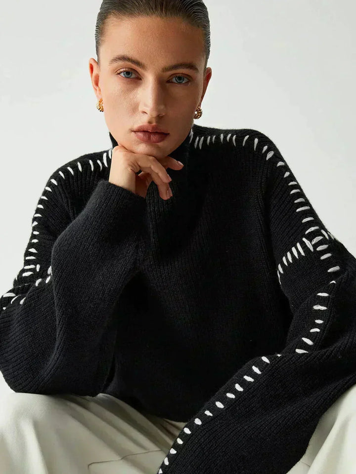 A woman wearing an oversized mock-neck sweater with whipstitch detailing, cosy and stylish.