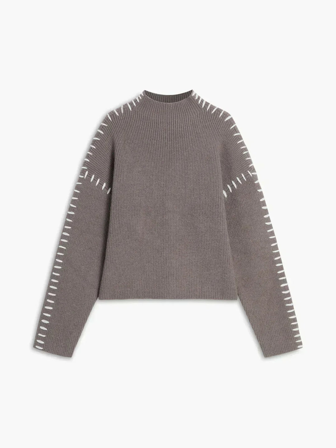 A woman wearing an oversized mock-neck sweater with whipstitch detailing, cosy and stylish.