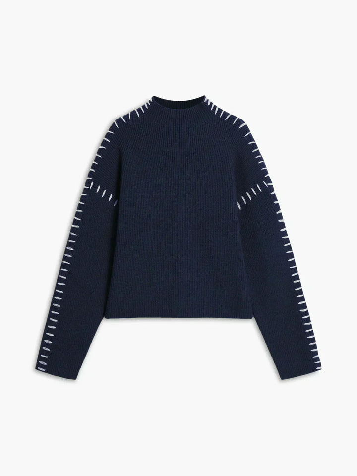 A woman wearing an oversized mock-neck sweater with whipstitch detailing, cosy and stylish.