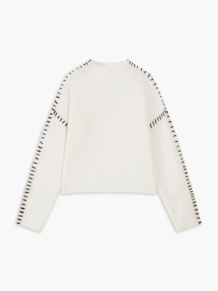 A woman wearing an oversized mock-neck sweater with whipstitch detailing, cosy and stylish.