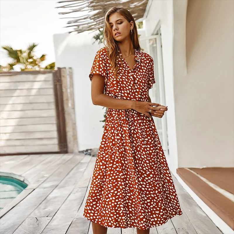 Woman wearing the Alicia™ printed summer midi dress with a flowing skirt, out for a bright summer stroll.