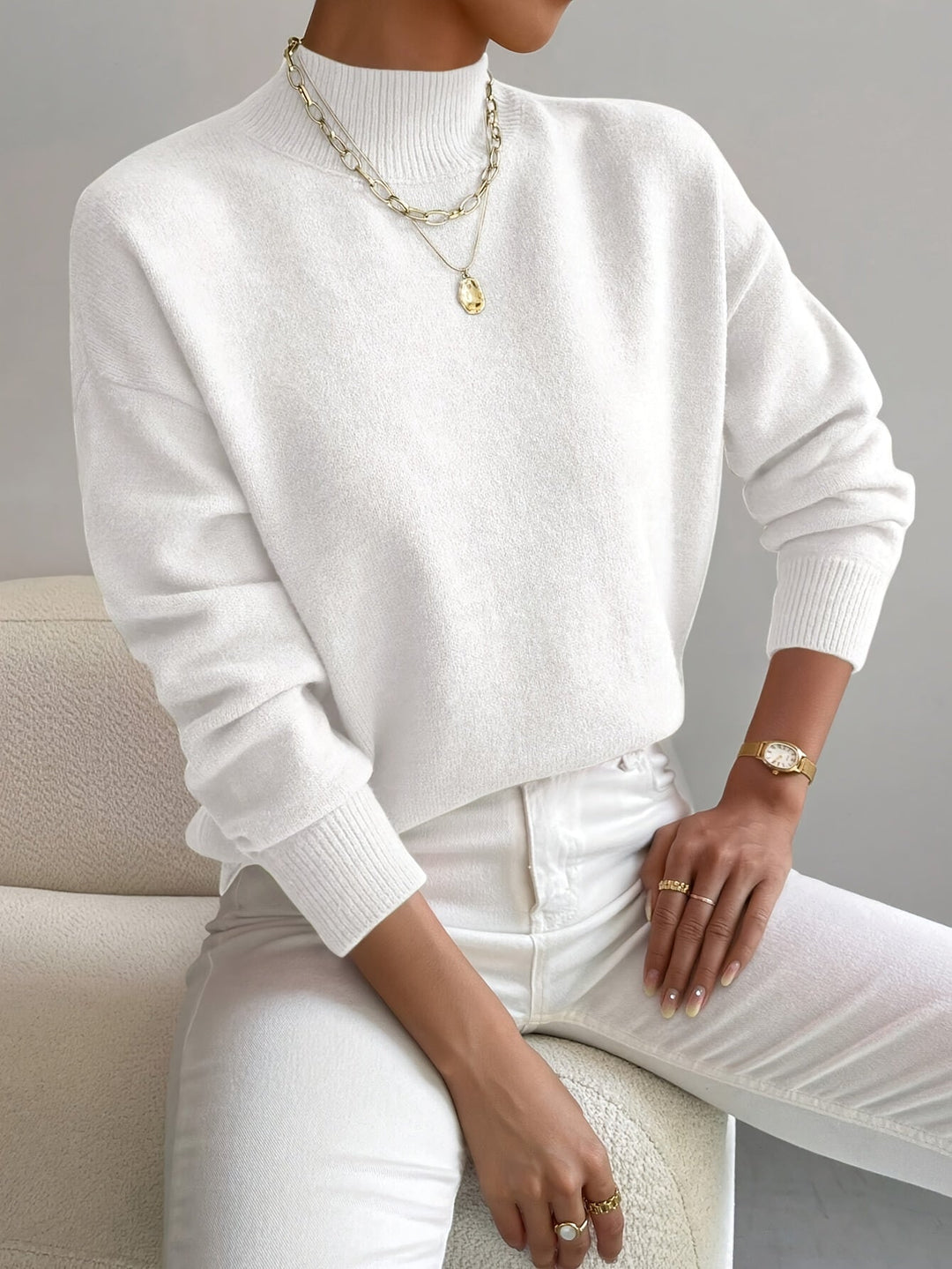 A woman wearing an elegant warm sweater with a modern stand collar, soft and refined.