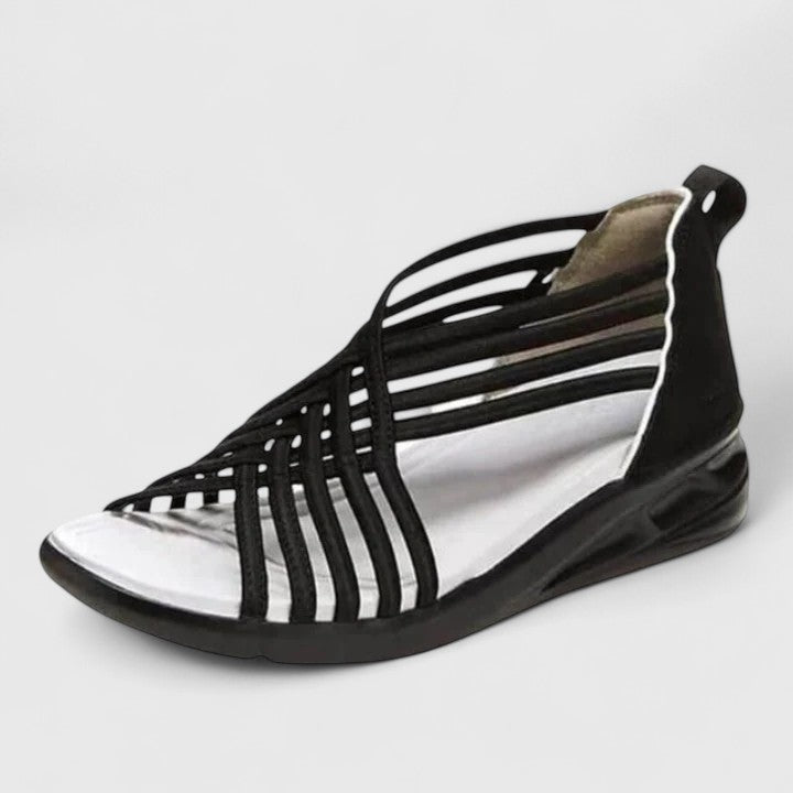 A woman walking comfortably in wide-fit multi-strap orthopaedic sandals with an open design.
