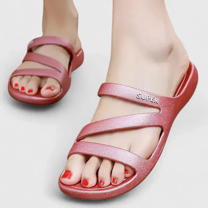 A woman walking confidently outdoors in supportive, cushioned orthopaedic sandals.