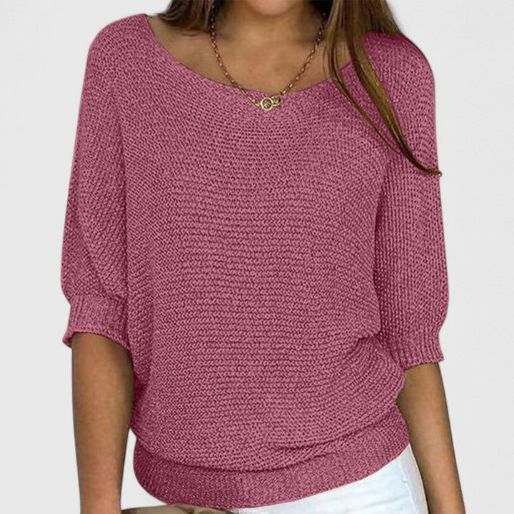 A woman wearing a soft purple sweater with a wide neckline and gently shaped fit.