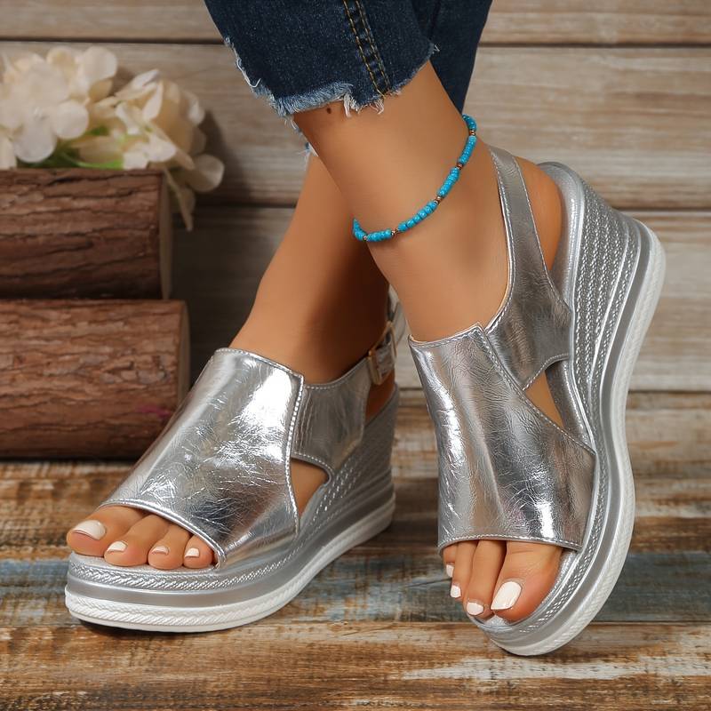 A woman wearing gold metallic sandals with a cushioned insole and wide, supportive fit.