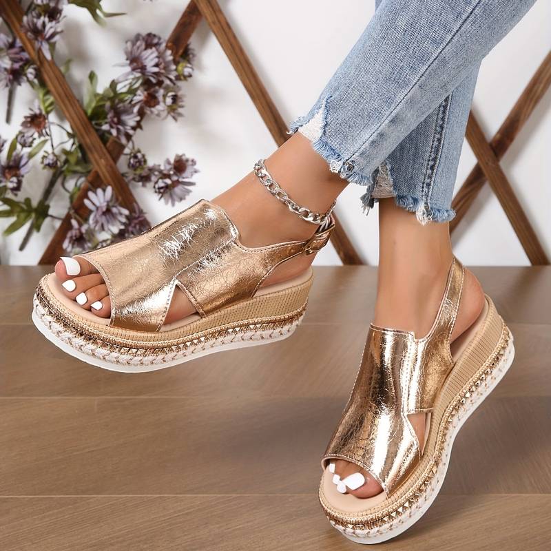 A woman wearing gold metallic sandals with a cushioned insole and wide, supportive fit.