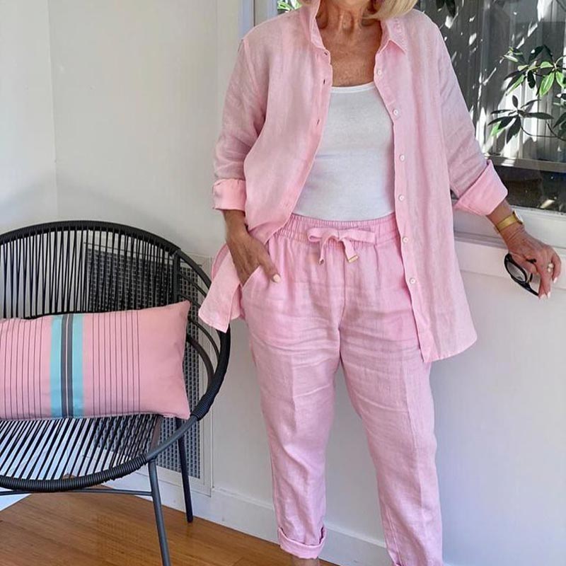 A woman wearing a light button-up shirt with matching drawstring lounge pants.