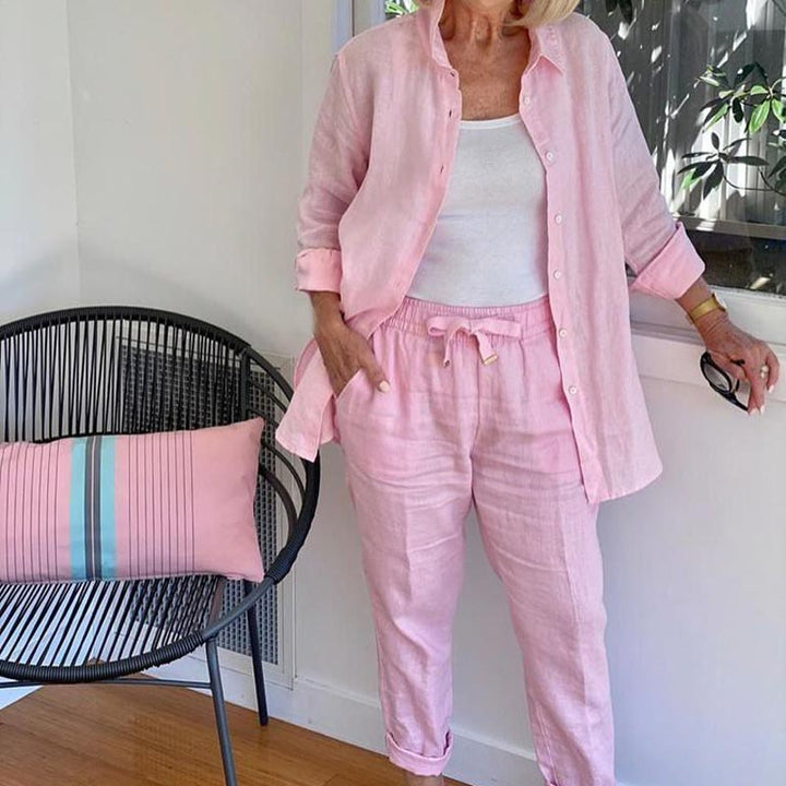 A woman wearing a light button-up shirt with matching drawstring lounge pants.