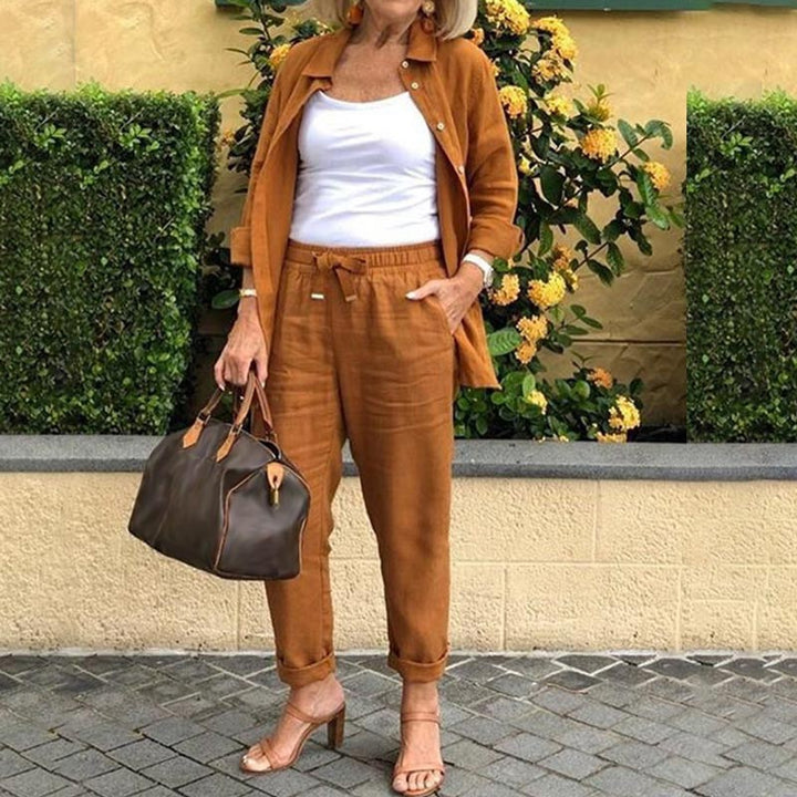 A woman wearing a light button-up shirt with matching drawstring lounge pants.