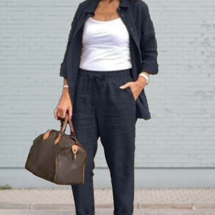 A woman wearing a light button-up shirt with matching drawstring lounge pants.