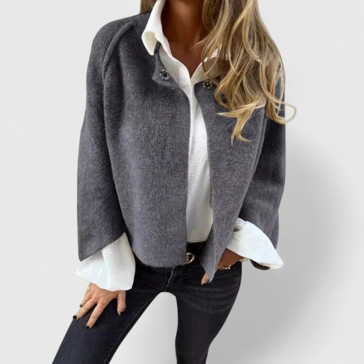 A woman wearing a relaxed open-front jacket over a blouse