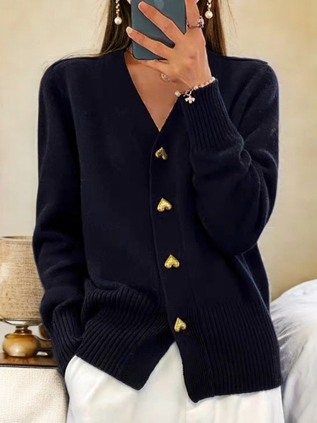 A woman wearing a soft V-neck button cardigan, elegant and cosy layered over a top.