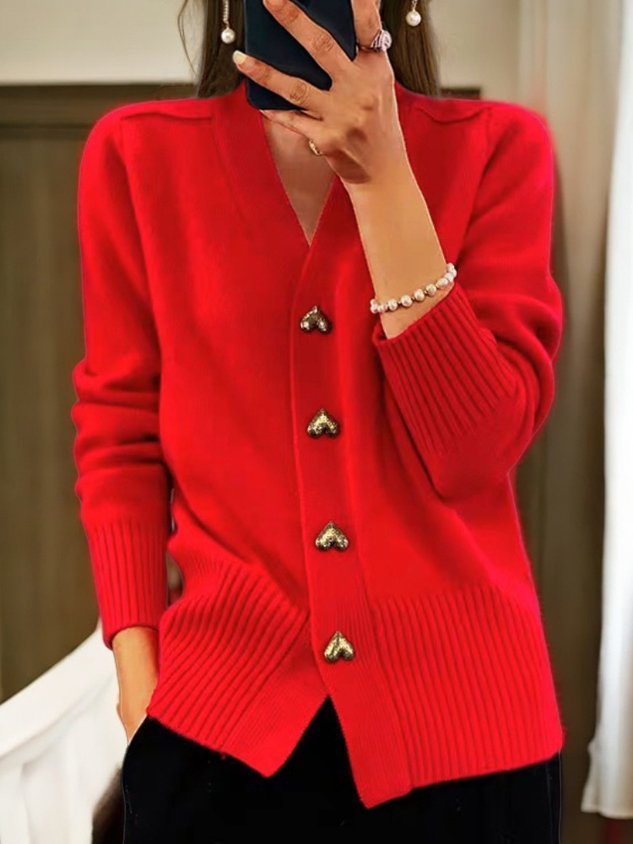 A woman wearing a soft V-neck button cardigan, elegant and cosy layered over a top.