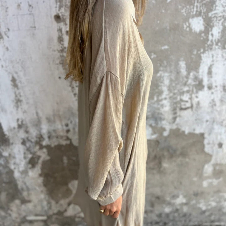 A woman wearing a relaxed beige button-front shirt with matching shorts