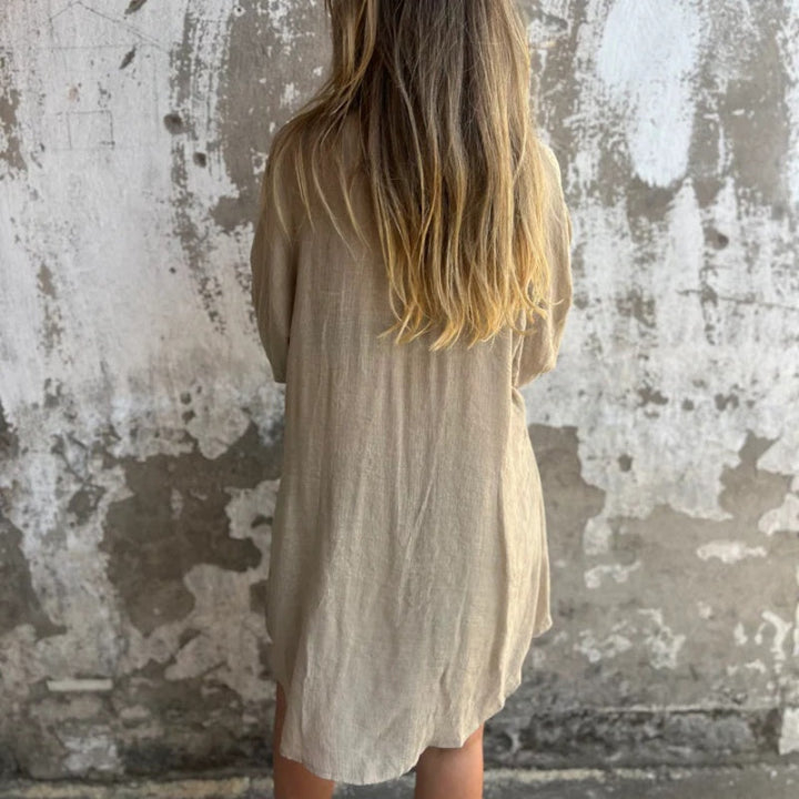 A woman wearing a relaxed beige button-front shirt with matching shorts