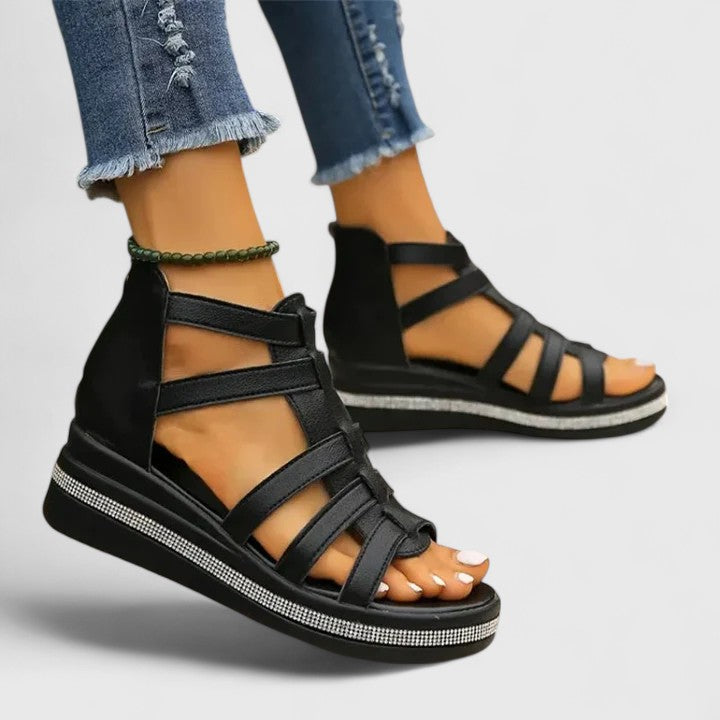 A woman in black strappy sandals walking confidently on a summer day, feet relaxed and supported.