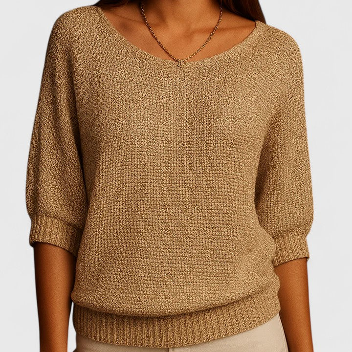 A woman wearing a soft purple sweater with a wide neckline and gently shaped fit.