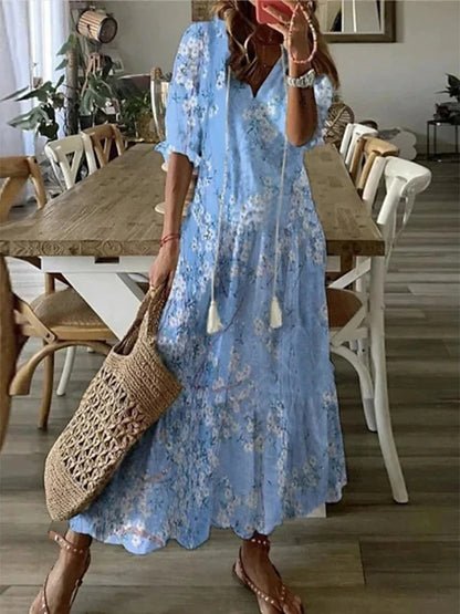 A woman wearing the Margaret boho midi dress with tassel ties at the neckline and a ruffled skirt.