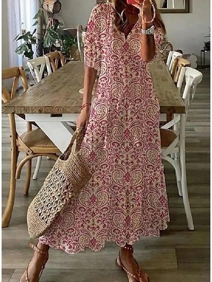 A woman wearing the Margaret boho midi dress with tassel ties at the neckline and a ruffled skirt.