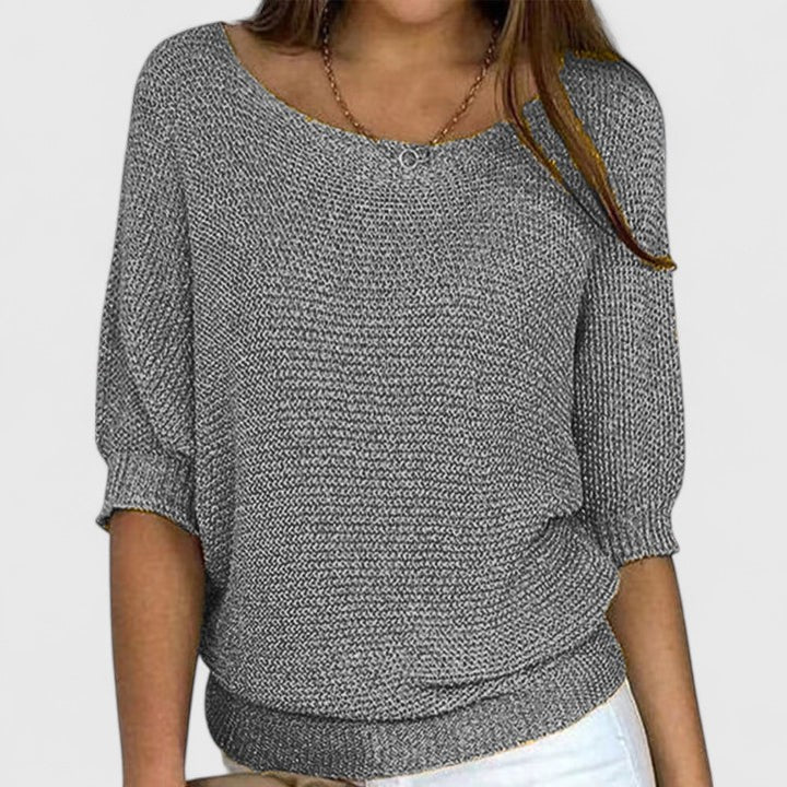 A woman wearing a soft purple sweater with a wide neckline and gently shaped fit.