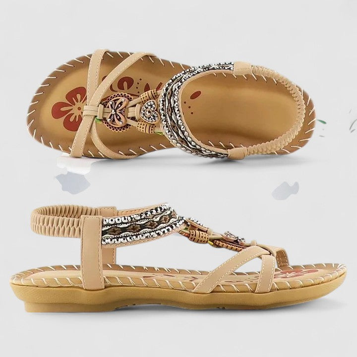 A woman walking comfortably outdoors in cushioned wide-fit orthopaedic sandals with a beaded T-strap and stretch slingback.