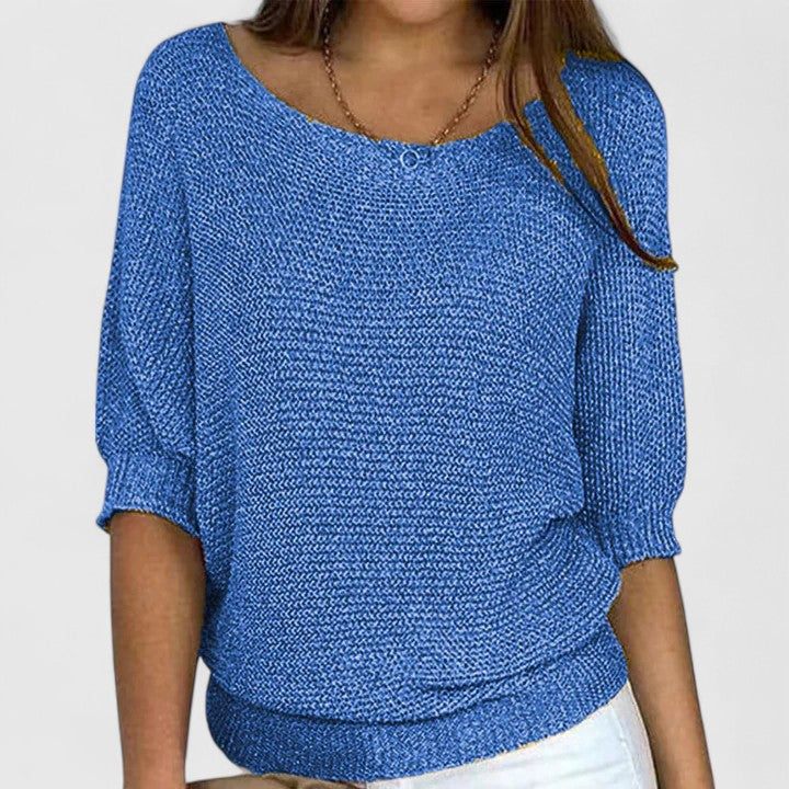 A woman wearing a soft purple sweater with a wide neckline and gently shaped fit.