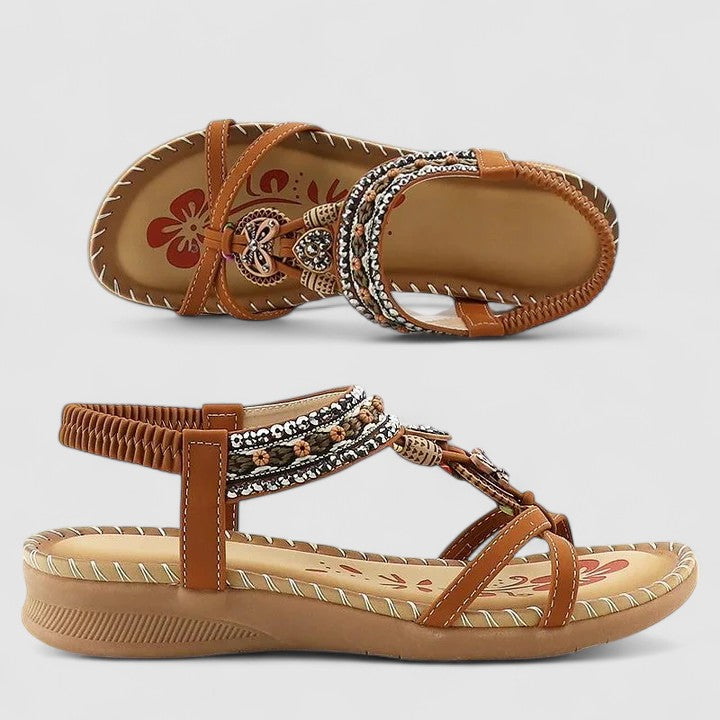 A woman wearing black beaded boho sandals with braided straps, a golden medallion and a stretchy slingback.