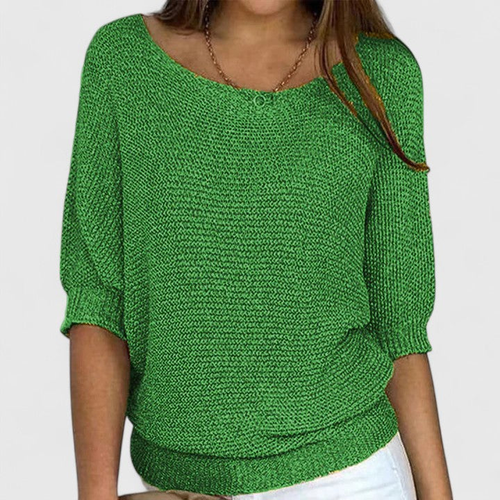 A woman wearing a soft purple sweater with a wide neckline and gently shaped fit.